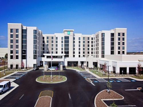 a large white building with a parking lot at Embassy Suites By Hilton Syracuse Destiny USA in Syracuse