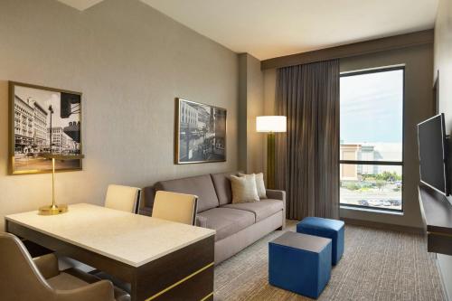 a living room with a couch and a table at Embassy Suites By Hilton Syracuse Destiny USA in Syracuse