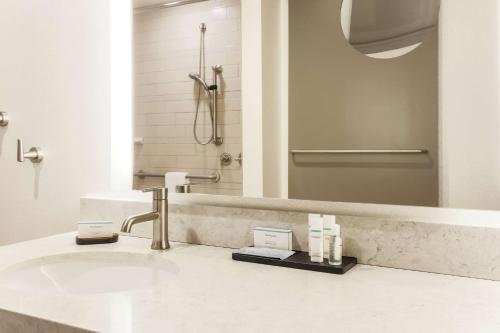 a bathroom with a sink and a mirror at Embassy Suites By Hilton Syracuse Destiny USA in Syracuse