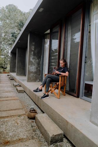 a woman sitting on a bench with a laptop at Kaliwa Lodge in Moshi