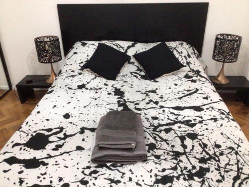 uma cama com um cobertor e almofadas preto e branco em Departamento en Palermo Parking included em Buenos Aires