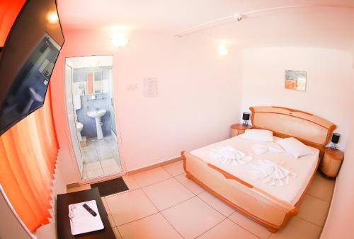 Hotel Proton K3 في نيبتون: غرفة نوم صغيرة بها سرير وحمام