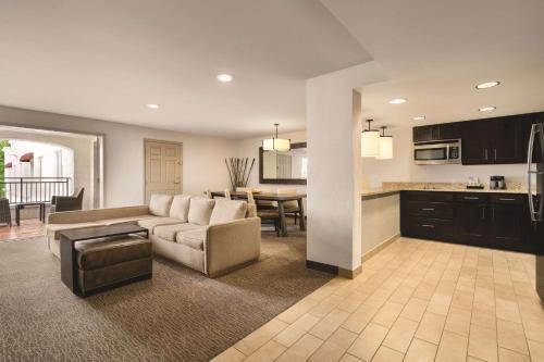 a living room with a couch and a kitchen at Homewood Suites Tucson St. Philip's Plaza University in Tucson