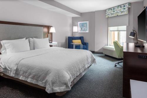 a hotel room with a bed and a chair at Hampton Inn & Suites Arlington Crystal City DCA in Arlington