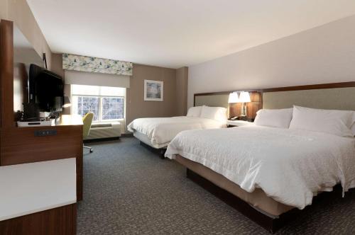 a hotel room with two beds and a flat screen tv at Hampton Inn & Suites Arlington Crystal City DCA in Arlington