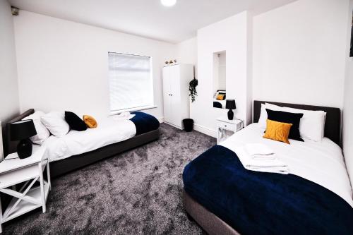 a bedroom with two beds and a desk at Cassia, 3 Bedrooms, Sleeps 5 in Norton Canes