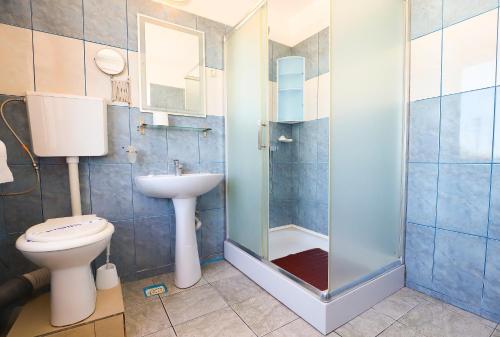 uma casa de banho com um chuveiro, um WC e um lavatório. em Hotel Proton K3 em Neptun