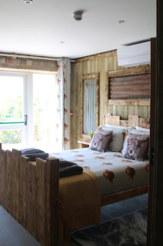 a bedroom with a large bed with a wooden headboard at The Moo-tel at Moody Meadows in Aberaeron