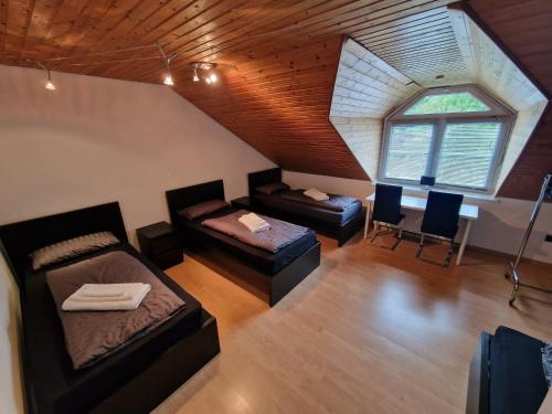 an attic room with two beds and a table at Spa Lounge Hannover in Hannover