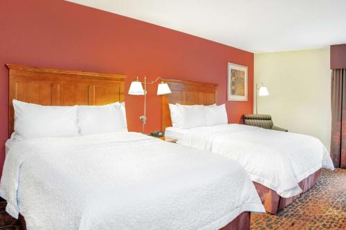 two beds in a hotel room with white sheets at Hampton Inn Merrillville in Merrillville