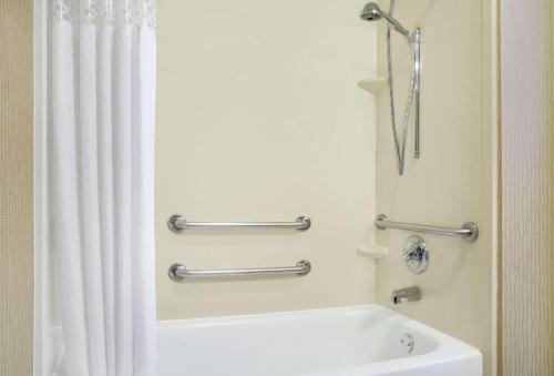 a bathroom with a white tub and a shower curtain at Hampton Inn Merrillville in Merrillville