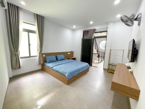1 dormitorio con 1 cama y TV. en Cá House en Quy Nhon