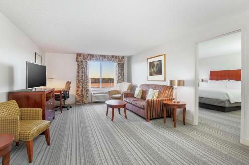 Hilton Garden Inn Roanoke Rapids في رونوك رابيدز: غرفة في الفندق مع أريكة وسرير