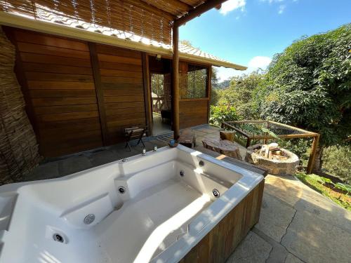 a large white bath tub in front of a house at Sítio Balango: Seu refúgio em Domingos Martins. Chalés para casais e casa para grupo de pessoas in Domingos Martins