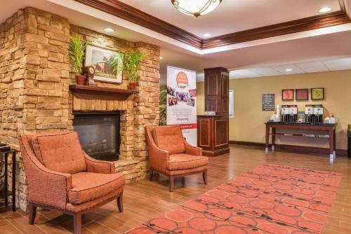 a waiting room with two chairs and a stone fireplace at Hampton Inn Statesville in Statesville