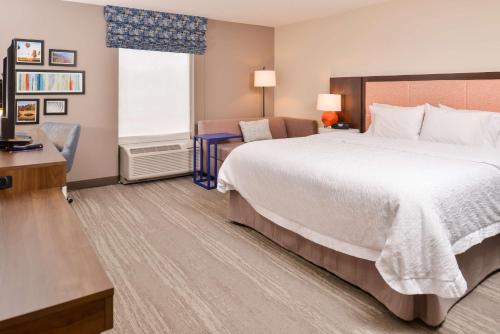 a hotel room with a large bed and a desk at Hampton Inn Statesville in Statesville