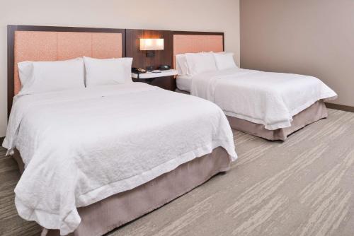 two beds in a hotel room with white sheets at Hampton Inn Statesville in Statesville