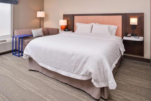 a hotel room with a large bed and a chair at Hampton Inn Statesville in Statesville