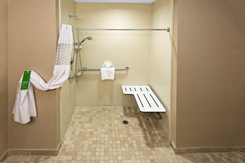 a bathroom with a shower with a bench in it at Hampton Inn Statesville in Statesville