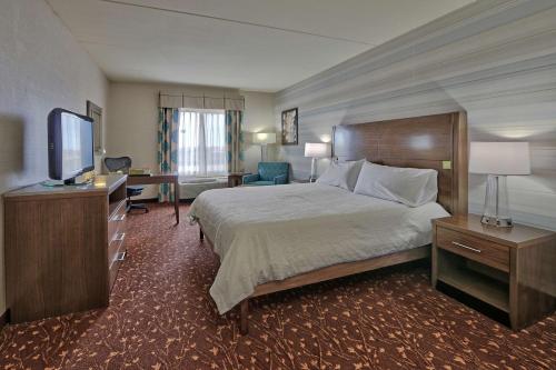 a hotel room with a bed and a television at Hilton Garden Inn Albuquerque Airport in Albuquerque