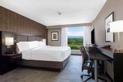 um quarto de hotel com uma cama, uma secretária e um computador em DoubleTree by Hilton Denver Cherry Creek, CO em Denver