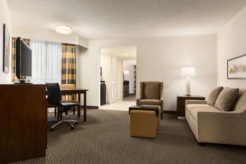 a hotel room with a couch and a desk and chair at Embassy Suites by Hilton Baltimore at BWI Airport in Linthicum Heights