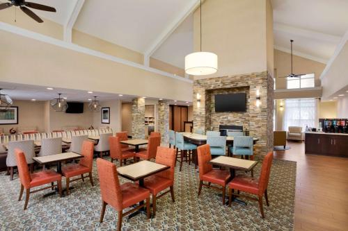 a restaurant with tables and chairs and a fireplace at Homewood Suites by Hilton Houston-Willowbrook Mall in Houston