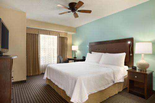 a hotel room with a bed and a ceiling fan at Homewood Suites by Hilton Houston-Willowbrook Mall in Houston