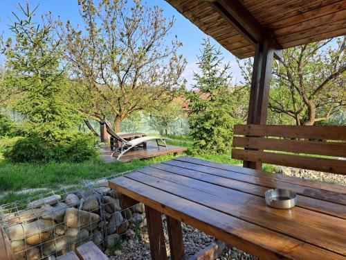 a wooden table on a porch with a bench at Zen Garden in Oradea