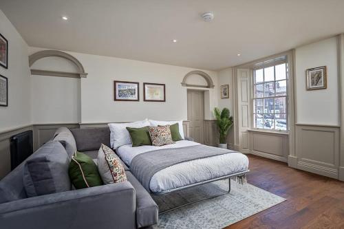 a living room with a couch and a window at Paradise Square-Remodelled 18th Century Apartment in Sheffield