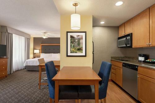 a hotel room with a table and a room with a bed at Homewood Suites by Hilton Allentown-Bethlehem Airport in Bethlehem
