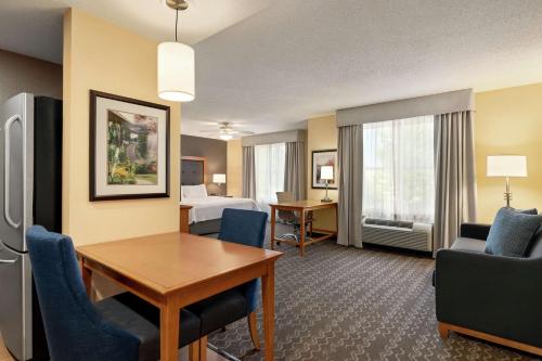 a hotel room with a table and chairs and a bed at Homewood Suites by Hilton Allentown-Bethlehem Airport in Bethlehem