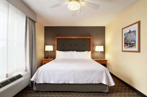 a bedroom with a white bed with two night stands and a window at Homewood Suites by Hilton Allentown-Bethlehem Airport in Bethlehem
