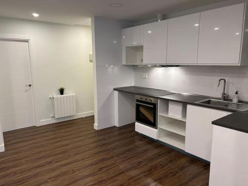 cocina con armarios blancos y suelo de madera en Bilbao apartamento a estrenar en Bilbao