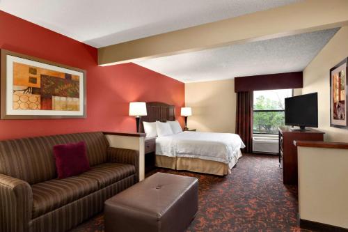 a hotel room with a bed and a couch at Hampton Inn Houston Willowbrook Mall in Houston