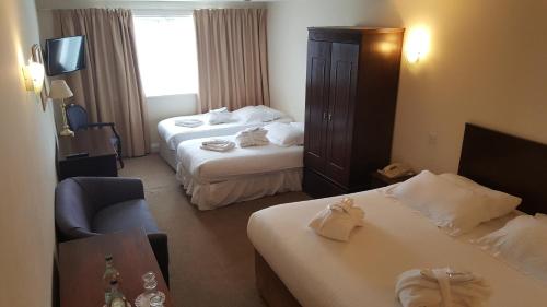 a hotel room with two beds and a television at Skylark Hotel in Southend-on-Sea