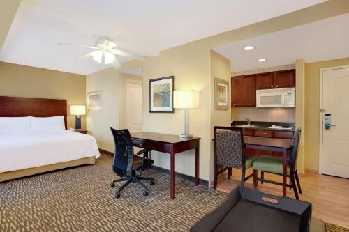ein Hotelzimmer mit einem Bett, einem Schreibtisch und einem Computer in der Unterkunft Homewood Suites by Hilton Tampa-Brandon in Tampa