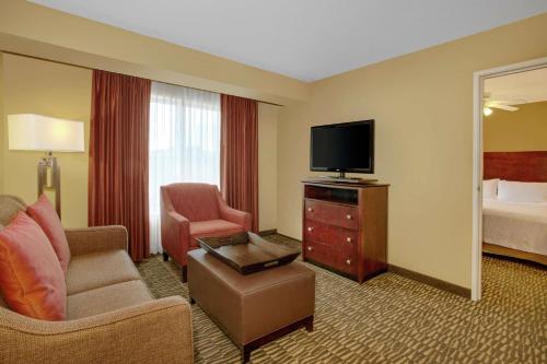 a hotel room with a television and a bed at Homewood Suites by Hilton Tampa-Brandon in Tampa