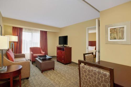 a hotel room with a television and a living room at Homewood Suites by Hilton Tampa-Brandon in Tampa