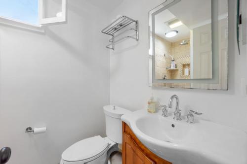 a bathroom with a sink and a toilet and a mirror at Beach & Breezes in Huntington Beach
