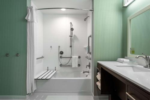 a bathroom with a tub and a shower with a sink at Home2 Suites by Hilton Charlotte University Research Park in Charlotte