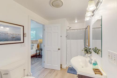 bagno bianco con lavandino e specchio di Sail Away Cottage a Nantucket