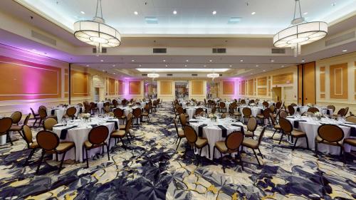 a banquet hall with tables and chairs and chandeliers at DoubleTree Boston North Shore Danvers in Danvers