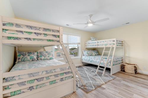 a bedroom with two bunk beds and a window at The Blue Whale Inn in Ocean Isle Beach