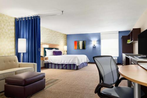 聖安吉洛的住宿－聖安吉洛希爾頓欣庭套房酒店，酒店客房带一张床、一张桌子和椅子