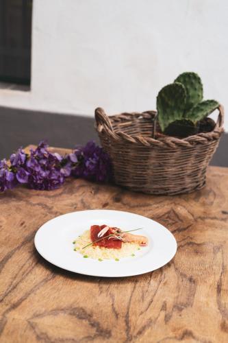 a plate of food on a wooden table with a basket at Agriturismo Giorgio in Mattinata