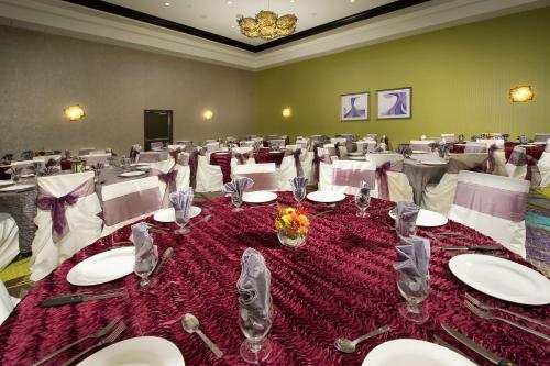 a large room with white tables and white chairs at Hilton Garden Inn College Station in College Station