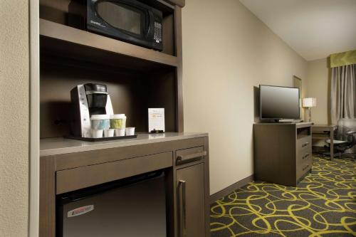 a hotel room with a coffee maker and a television at Hilton Garden Inn College Station in College Station