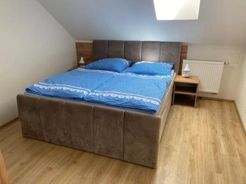 a large bed in a bedroom with a wooden floor at Hrusická restaurace a penzion in Hrusice