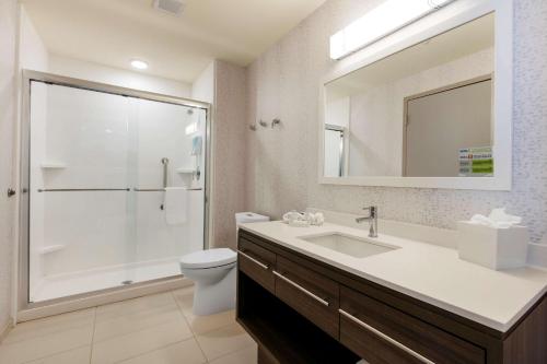 奥利夫布兰奇Home2 Suites By Hilton Olive Branch的带水槽、马桶和镜子的浴室